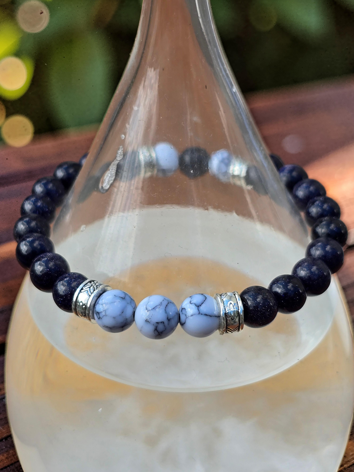 Men's stretch Bracelet with deep blue and white marble effect beads on a glass bottle