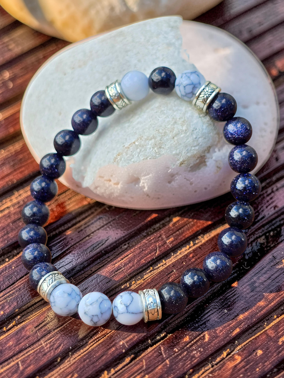 Beaded bracelet with blue and white stones on a wooden surface