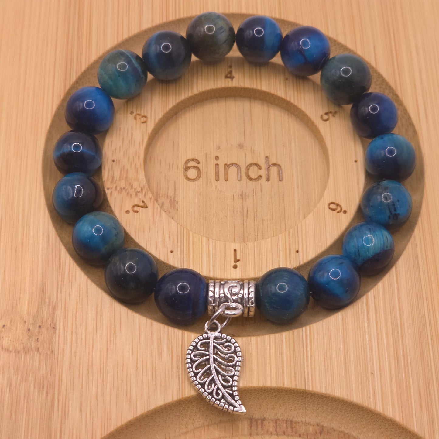 Handmade blue glass beaded bracelet on a wooden measuring board showing 6 inches in size