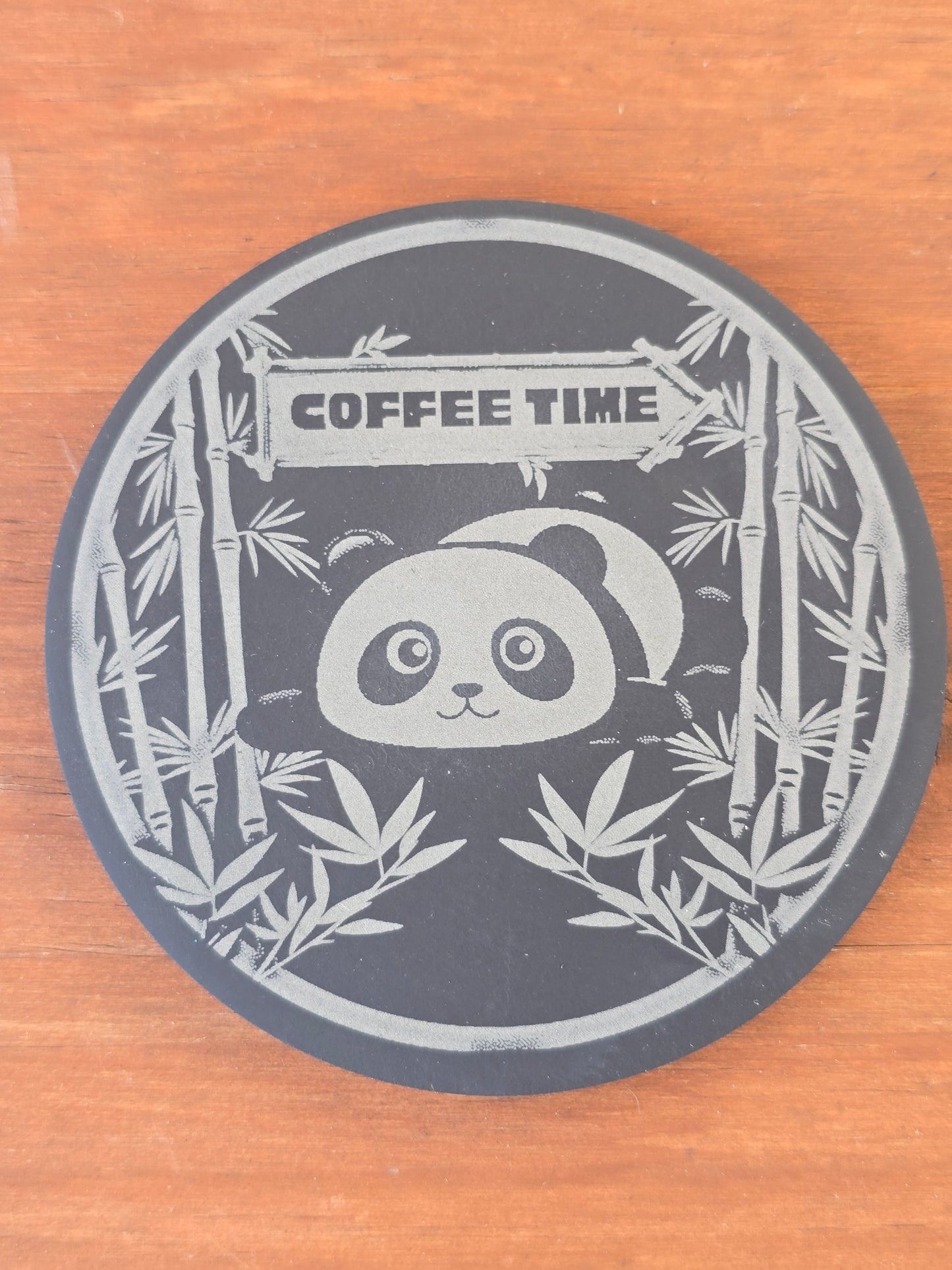 Circular coaster with panda design and 'Coffee Time' text on a wooden surface
