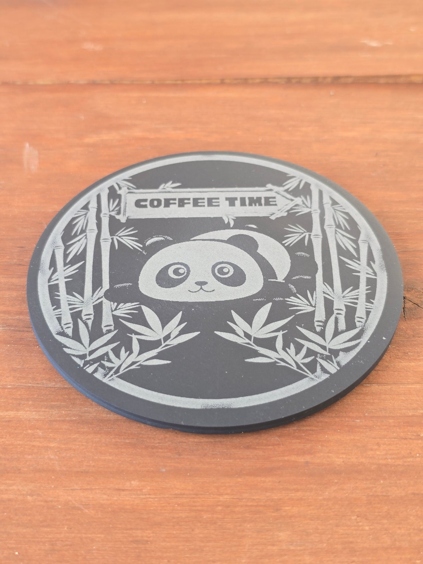 Circular coaster with panda design and 'Coffee Time' text on a wooden surface