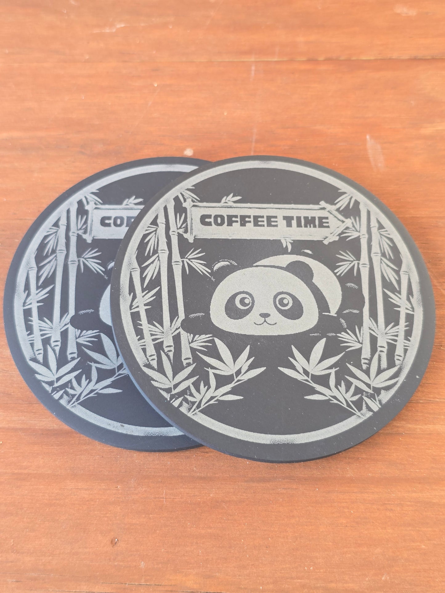 Decorative coaster with panda and bamboo design and 'Coffee Time' text on a wooden surface