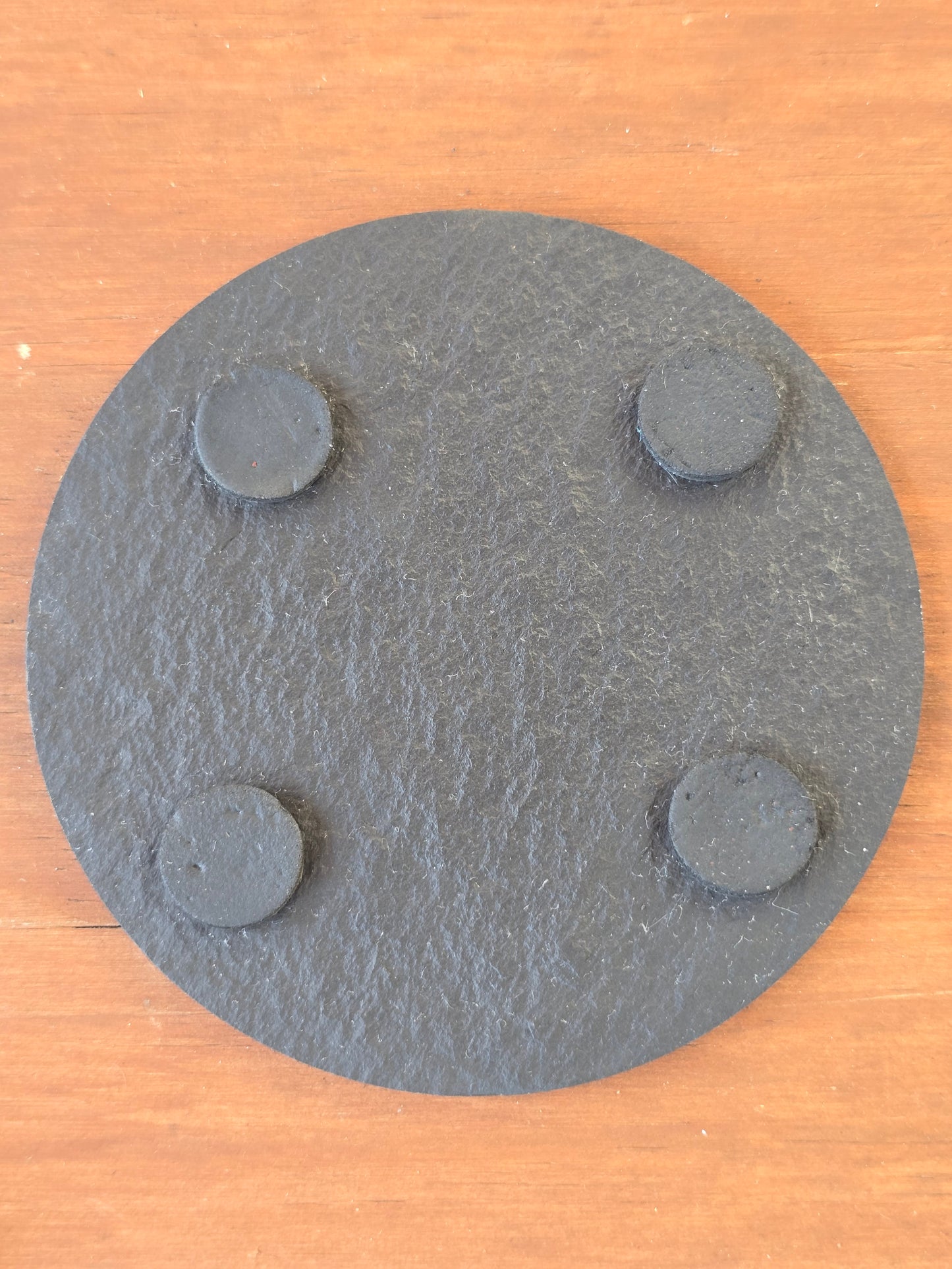 underside of a slate coaster with 4 felt feet