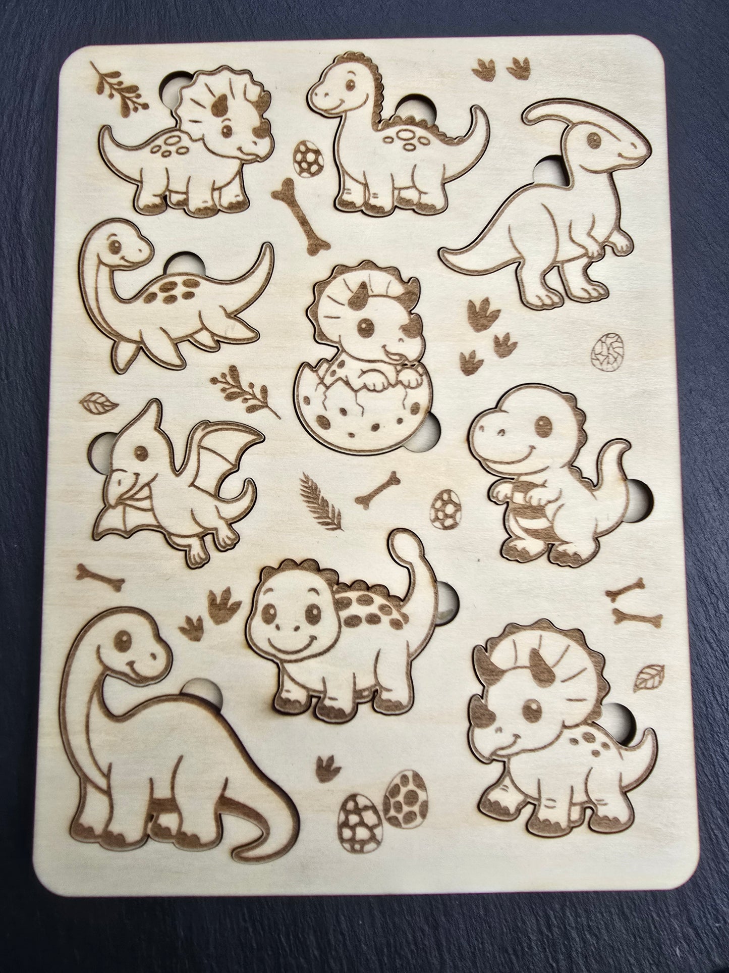 Wooden puzzle with dinosaur cutouts on a dark background