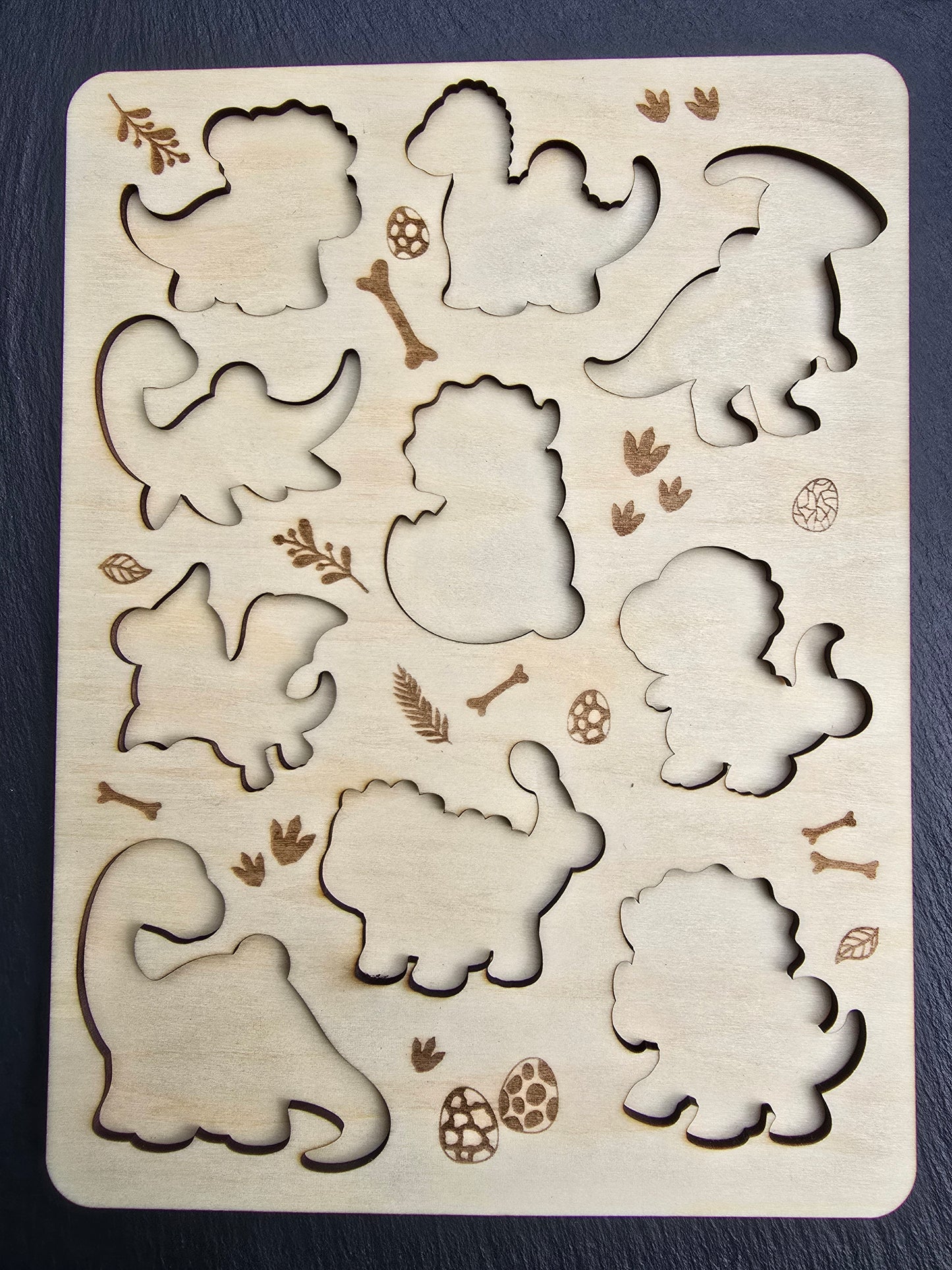 Wooden puzzle with dinosaur cut outs and decorative elements