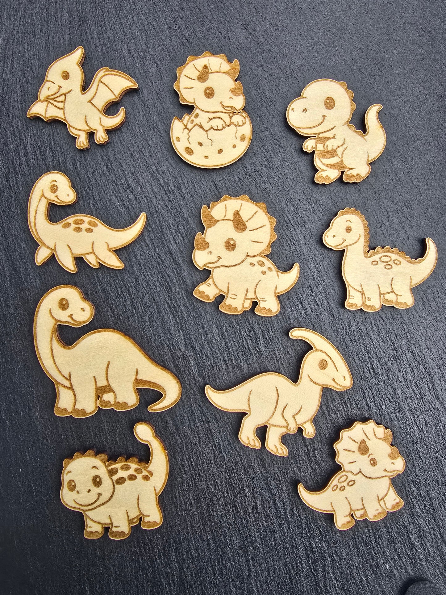 Set of wooden dinosaur shaped puzzle pieces on a dark slate background as part of a kids dinosaur puzzle board