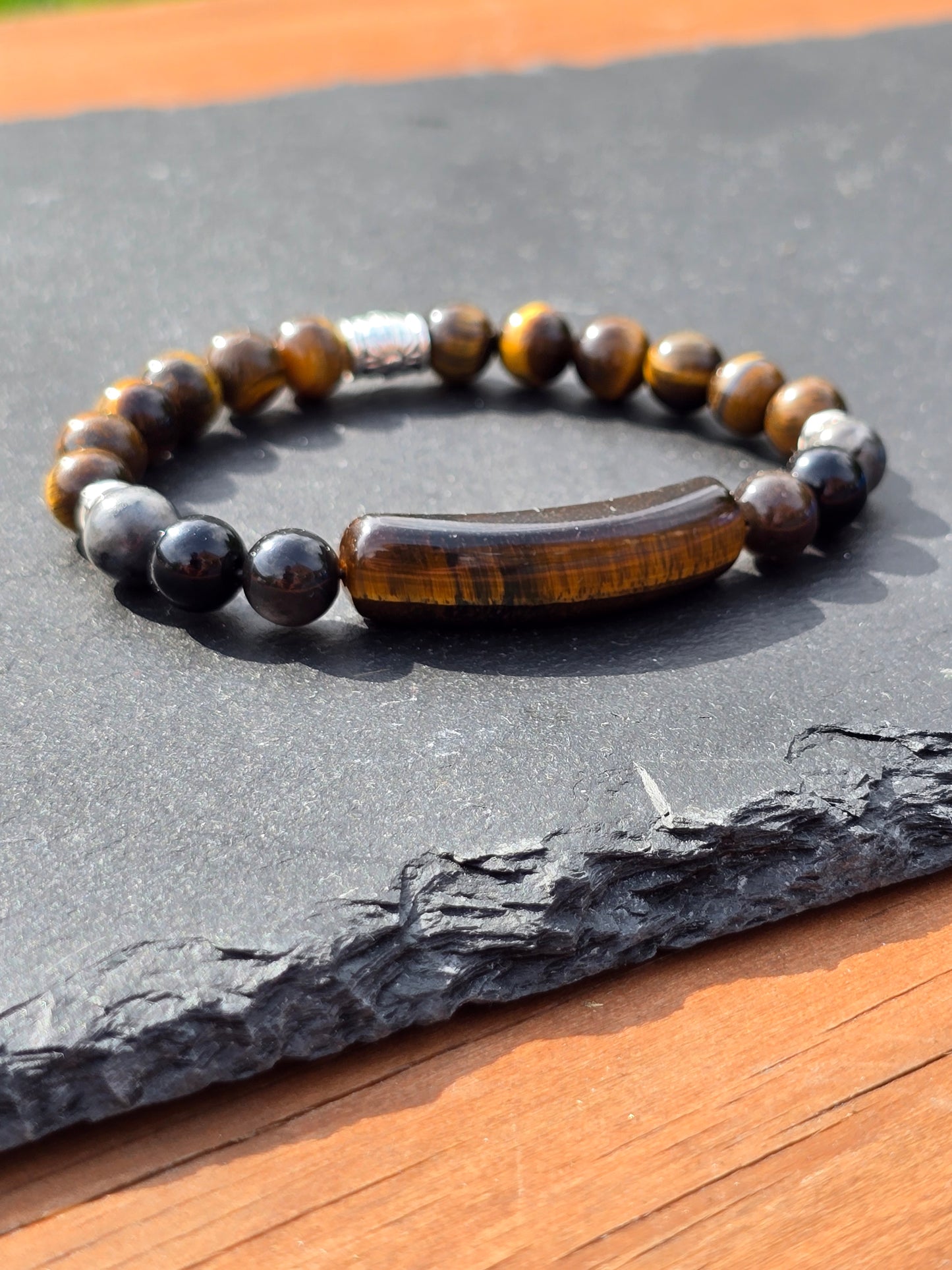 Men's tigers eye beaded bracelet on a slate surface