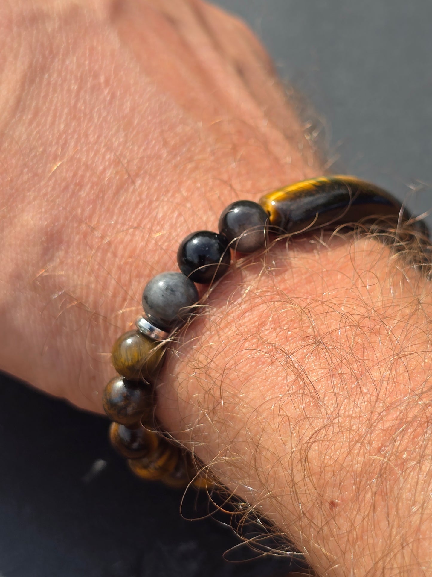 side view of a Men's tigers eye beaded bracelet showing the grey and black obsidian beads