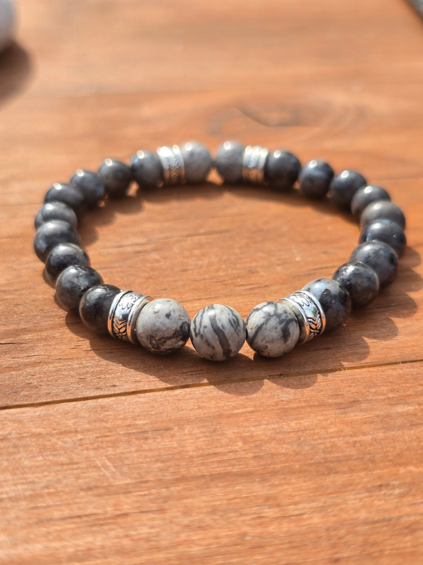 Men's Beaded bracelet with Grey and white stones on a wooden surface
