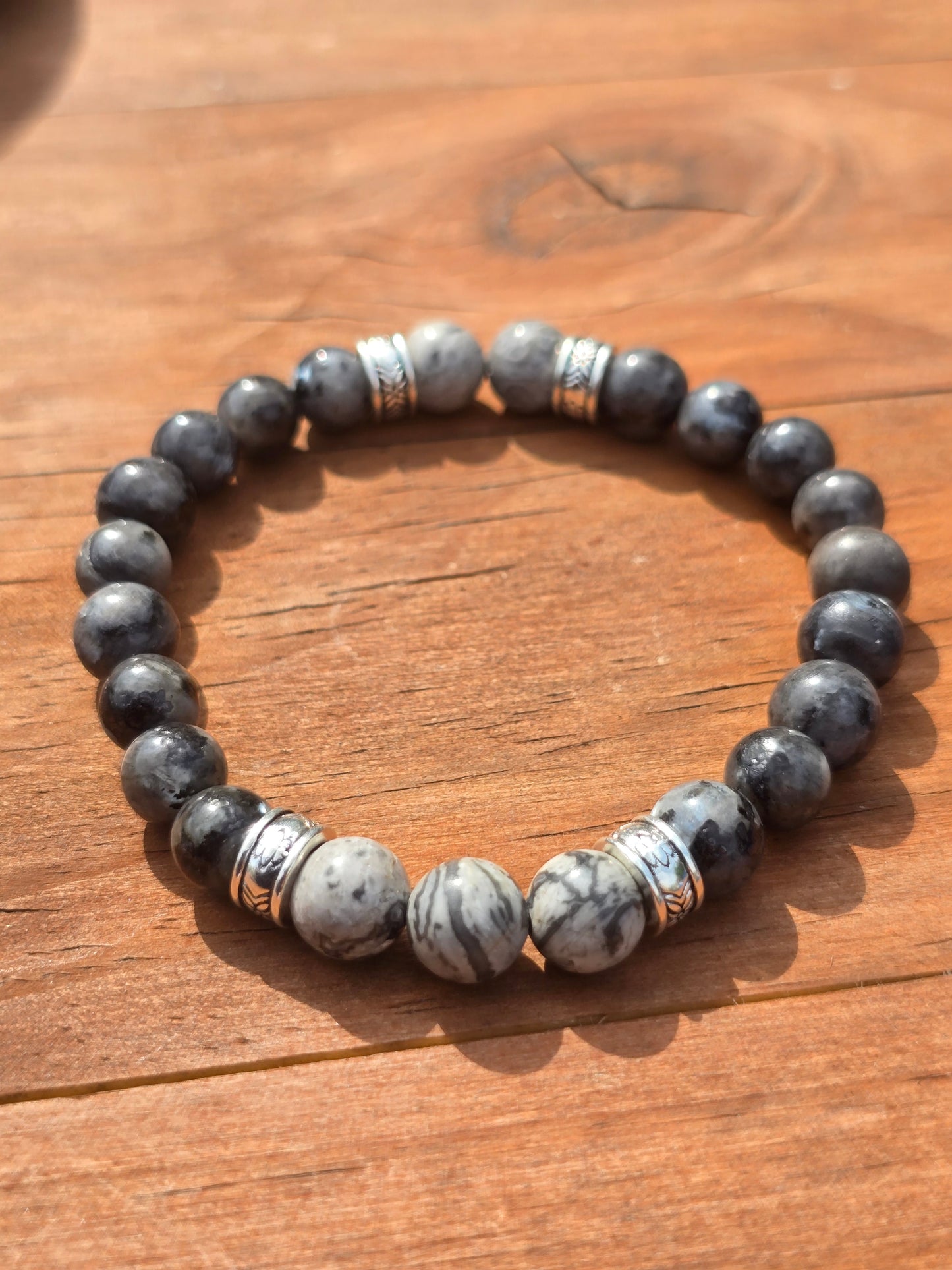 mens grey beaded elastic bracelet on a wooden surface