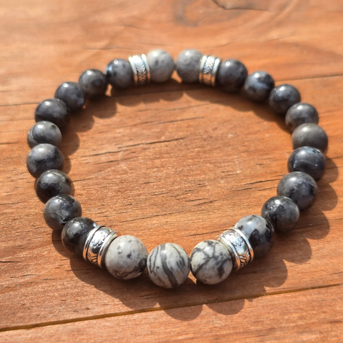 mens grey beaded elastic bracelet on a wooden surface