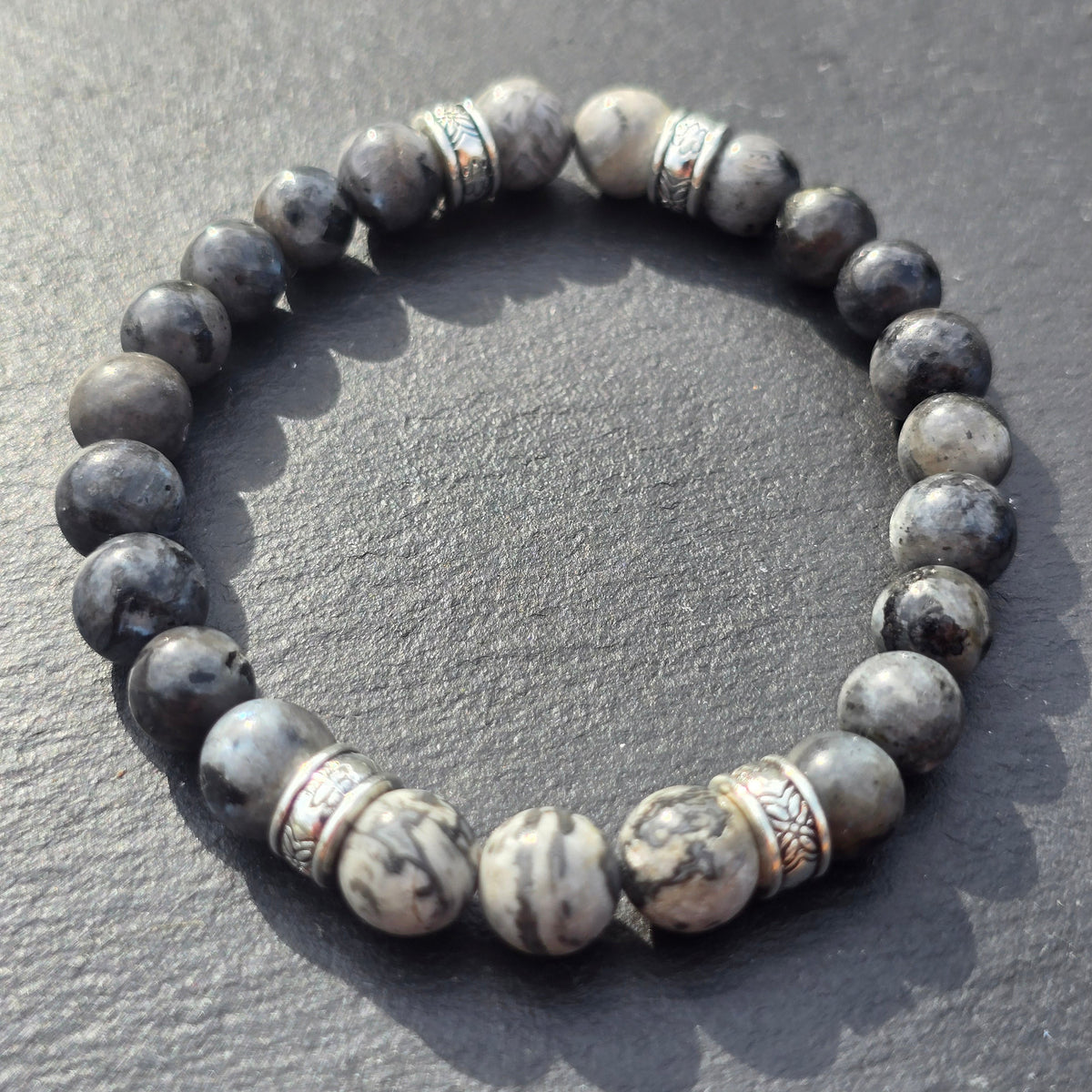Men's Elasticated grey beaded bracelet with stone-like beads on a slate surface