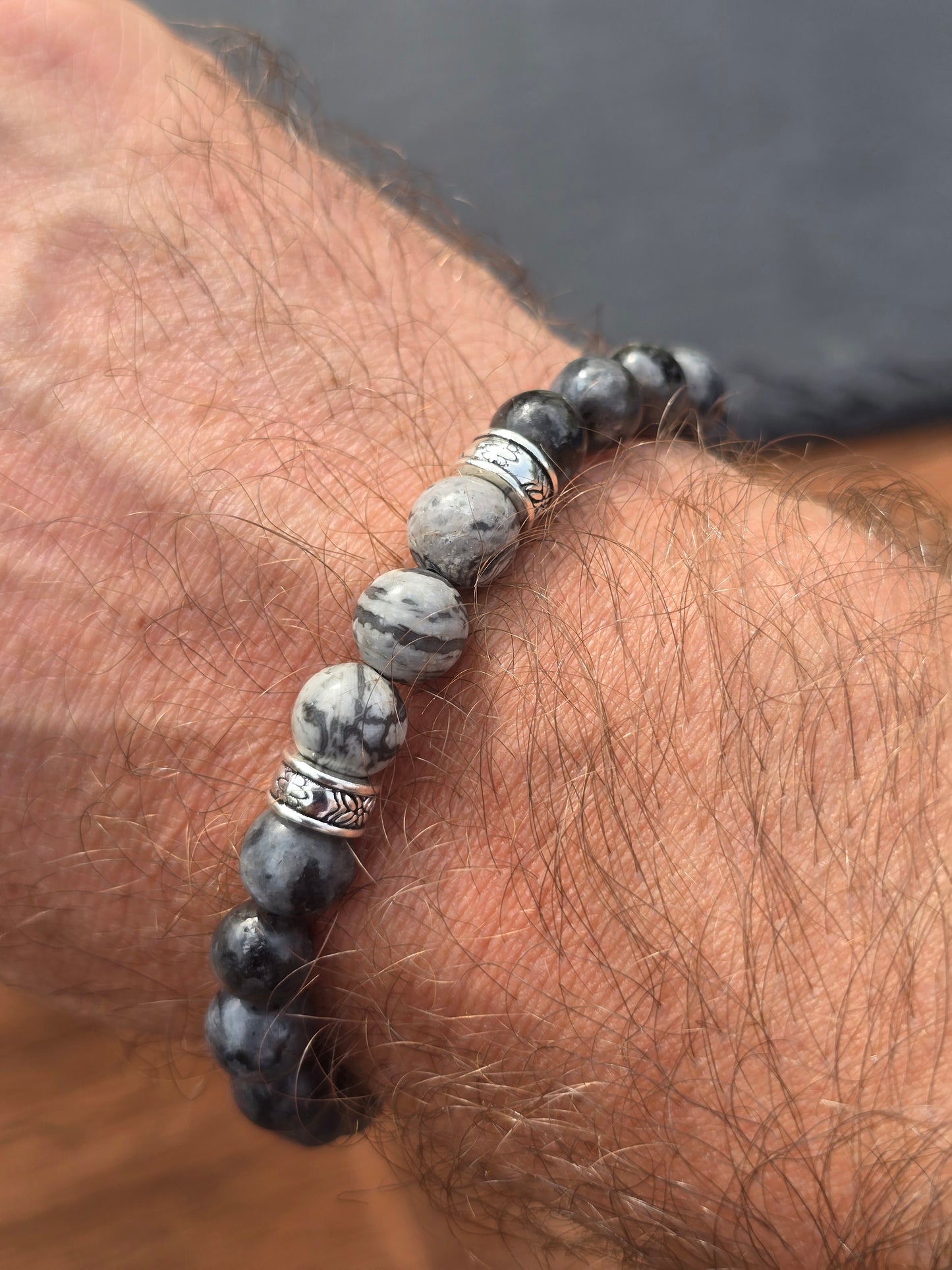 Close-up of a person's wrist wearing a beaded bracelet with stone-like beads.