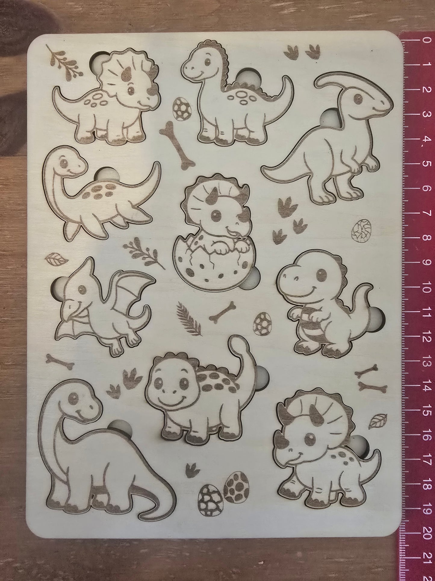 Dinosaur-themed wooden puzzle with measurement scale showing 20cm long