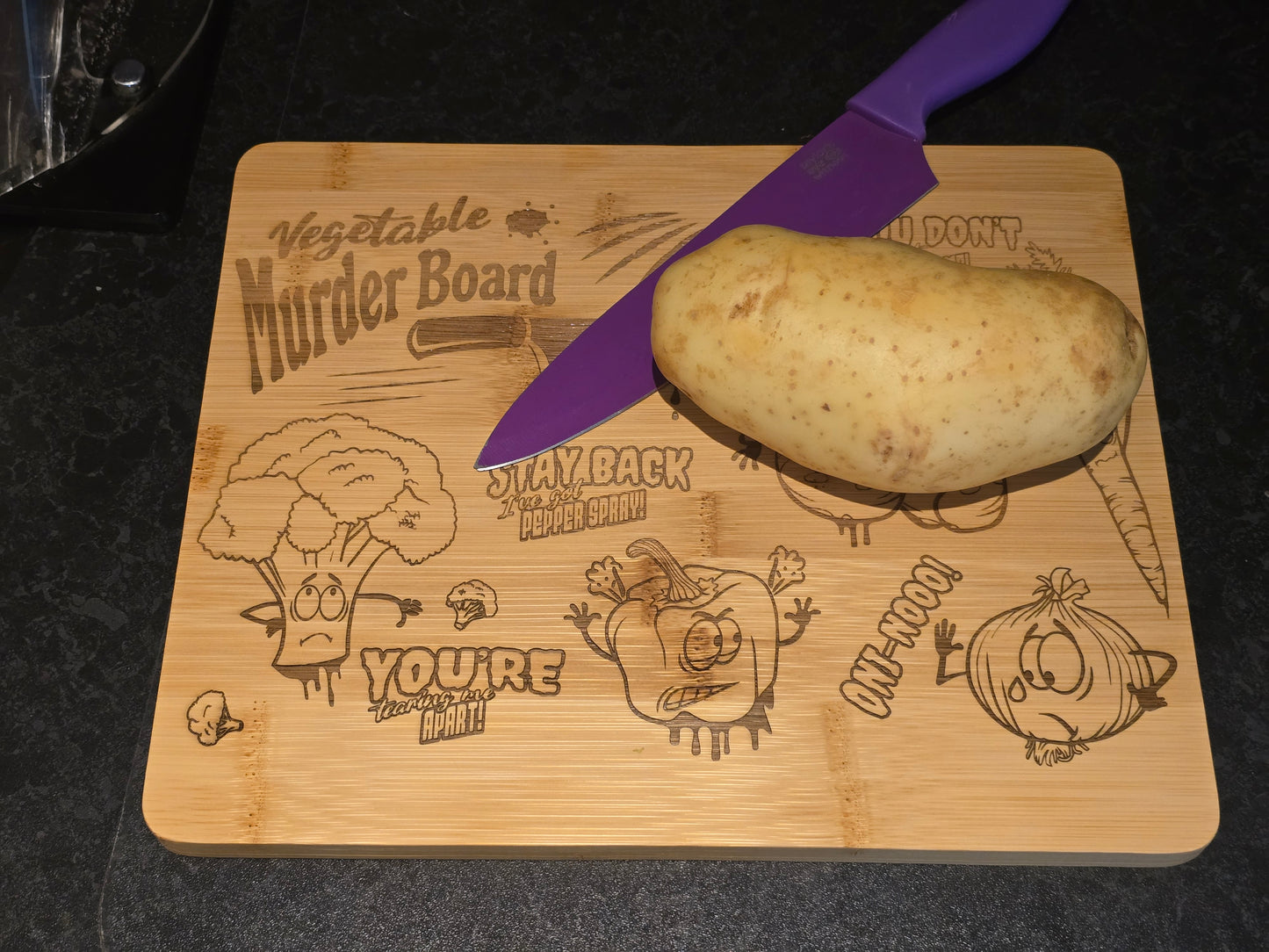 Potato on a cutting board with a purple knife, featuring comical vegetable-themed designs.