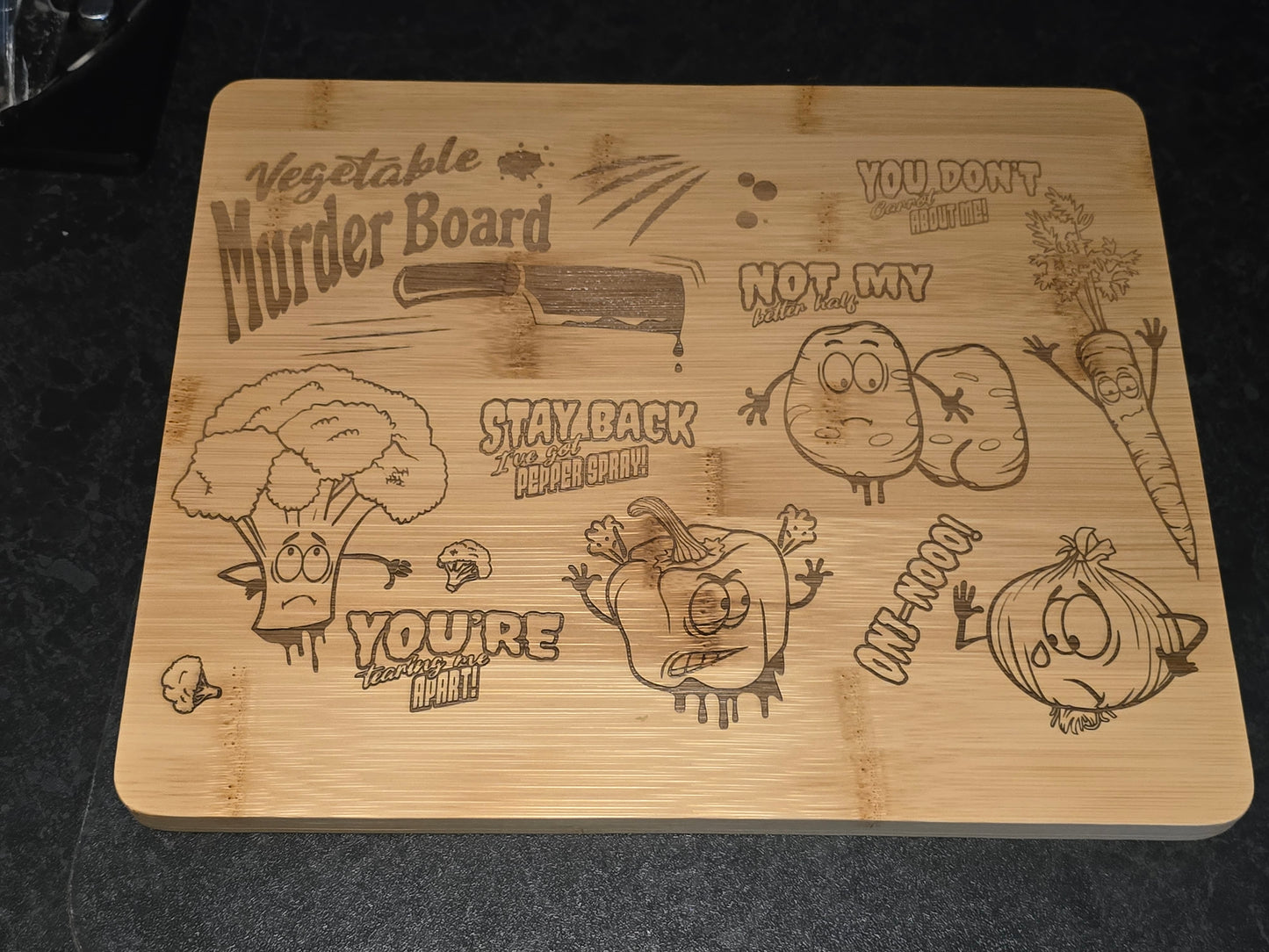 Wooden cutting board with cartoon vegetable designs and funny text on a kitchen work surface