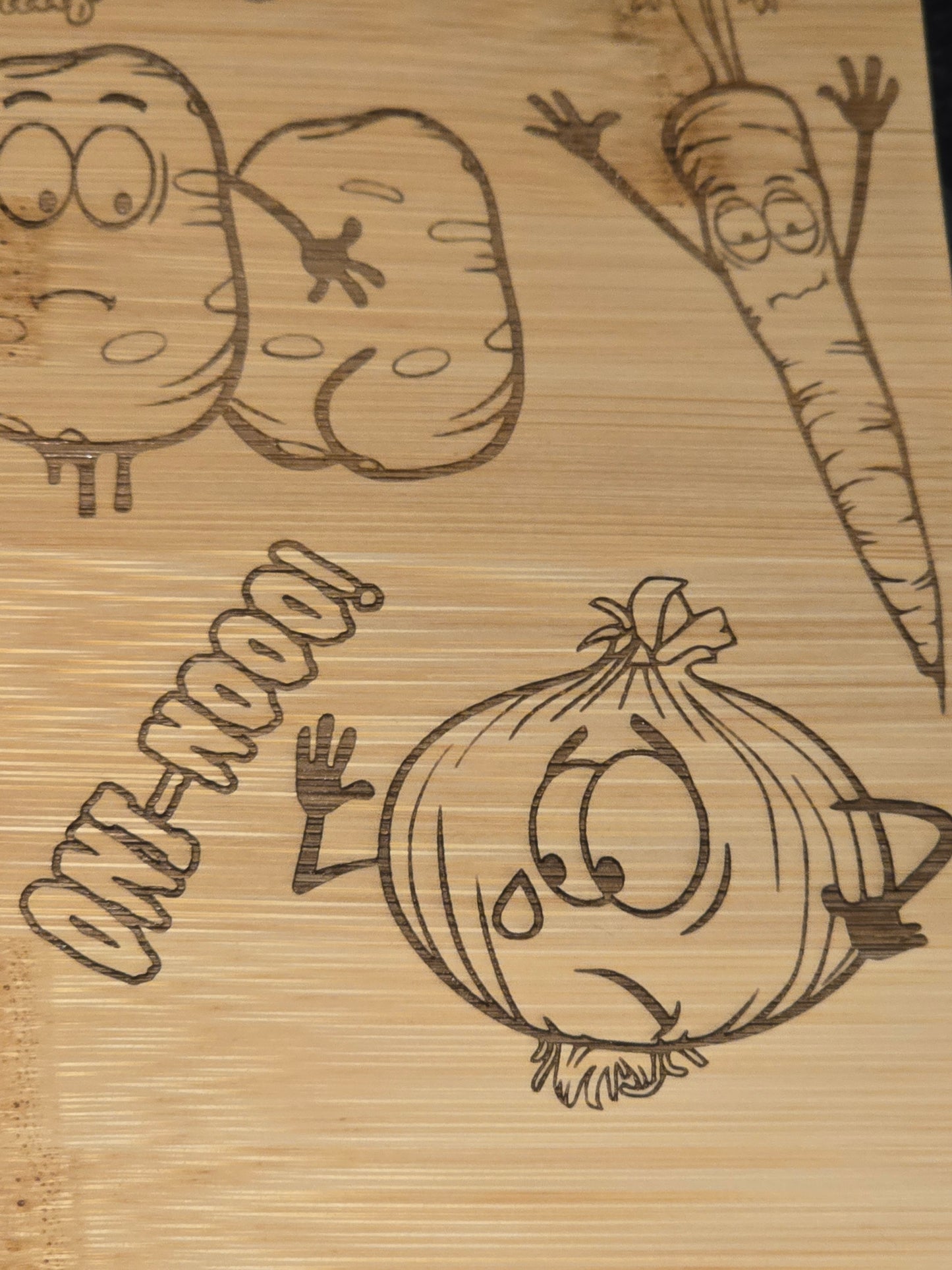 Wooden cutting board with engraved vegetable illustrations and text
