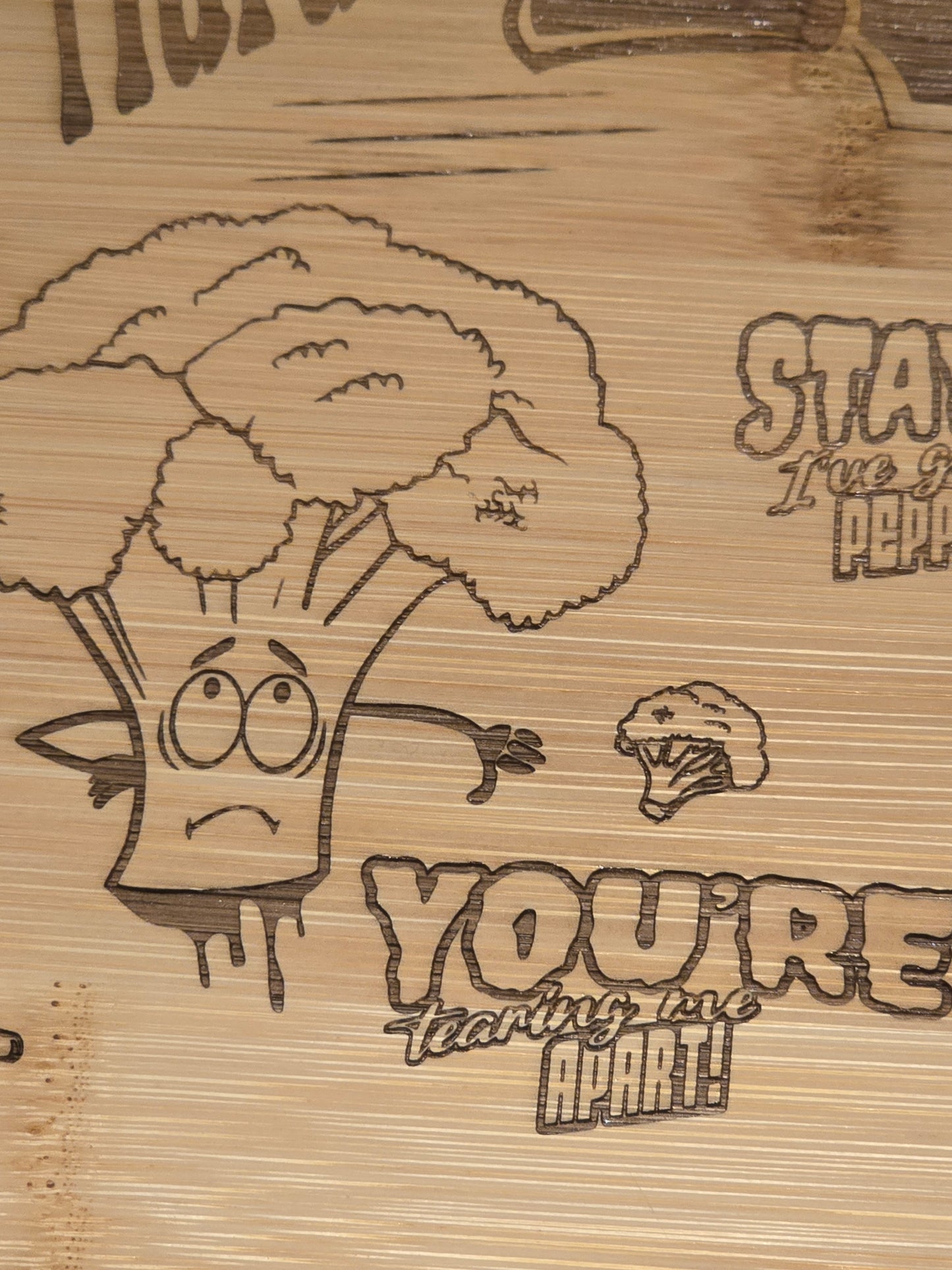 Wooden cutting board with engraved cartoon broccoli character and you're tearing me apart text