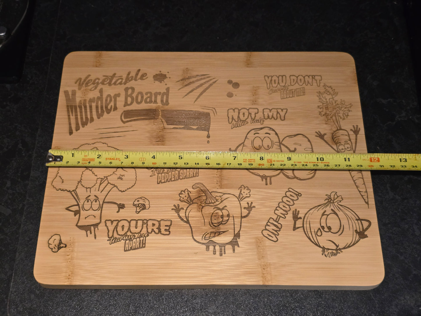 Wooden cutting board with humorous vegetable-themed designs and a measuring tape showing 30cm length