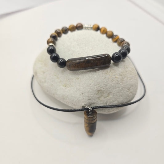 Beaded bracelet with black and brown beads on a white rock along with a tiger eye pendant necklace