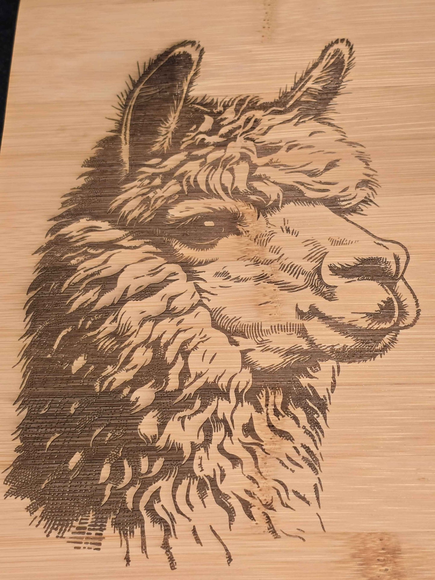 Engraved alpaca design on a wooden chopping board
