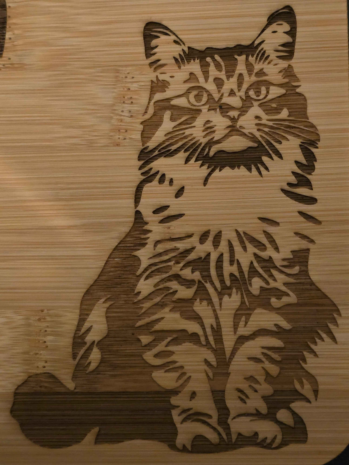 Engraved design of a cat on a wooden chopping board