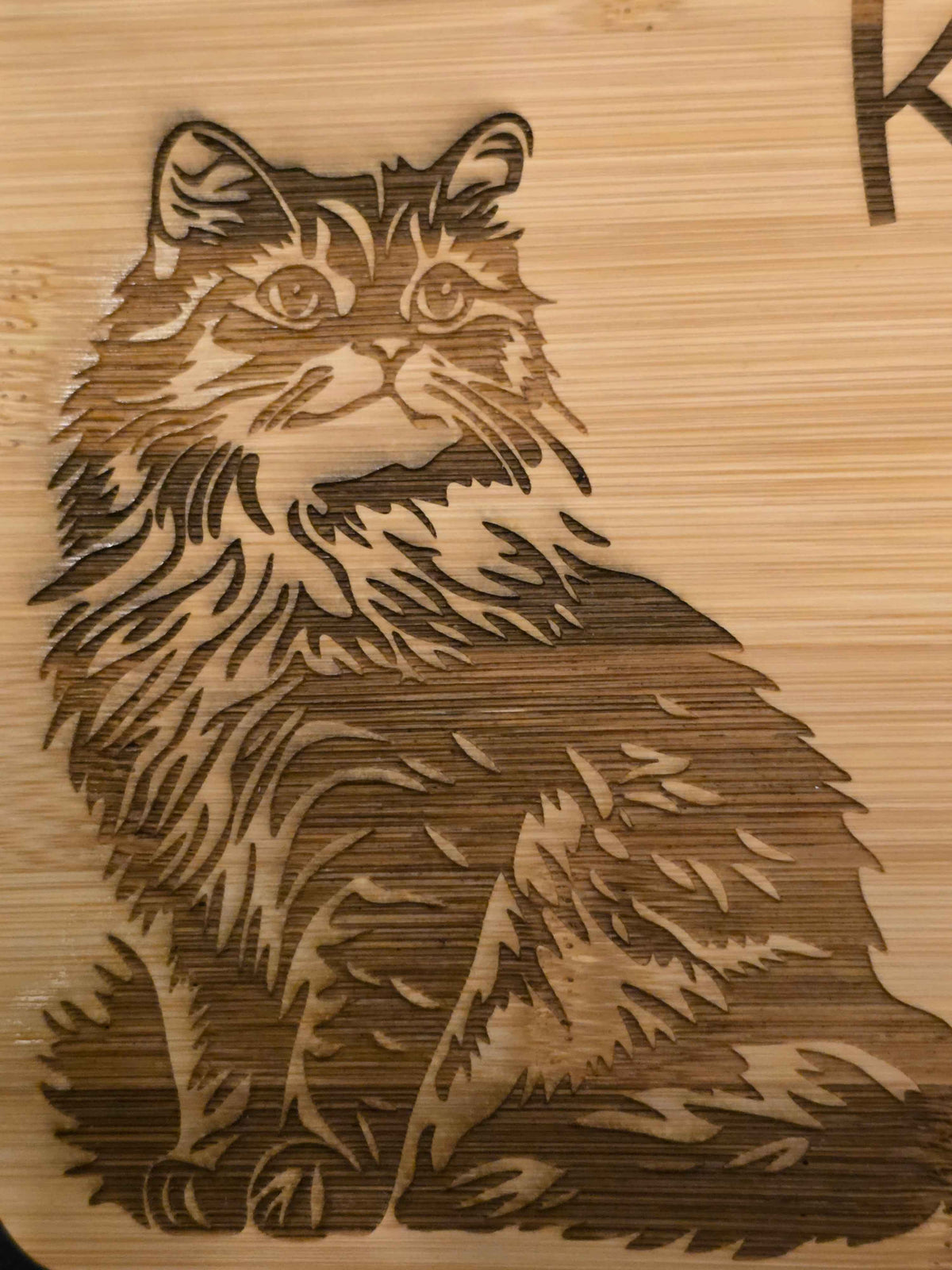 Laser-engraved cat design on a bamboo chopping board