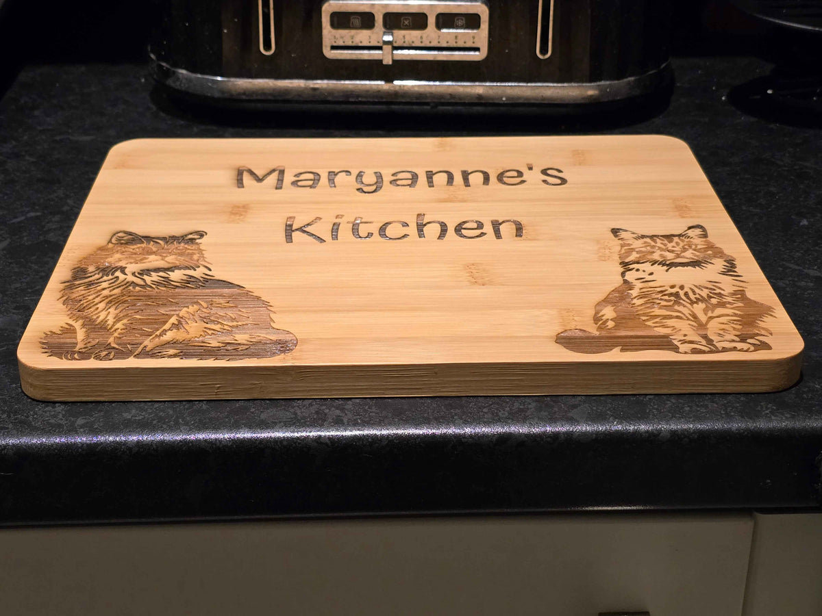 low angle shot of a Wooden cutting board with engraved cats and 'Maryanne's Kitchen' text on a kitchen counter.