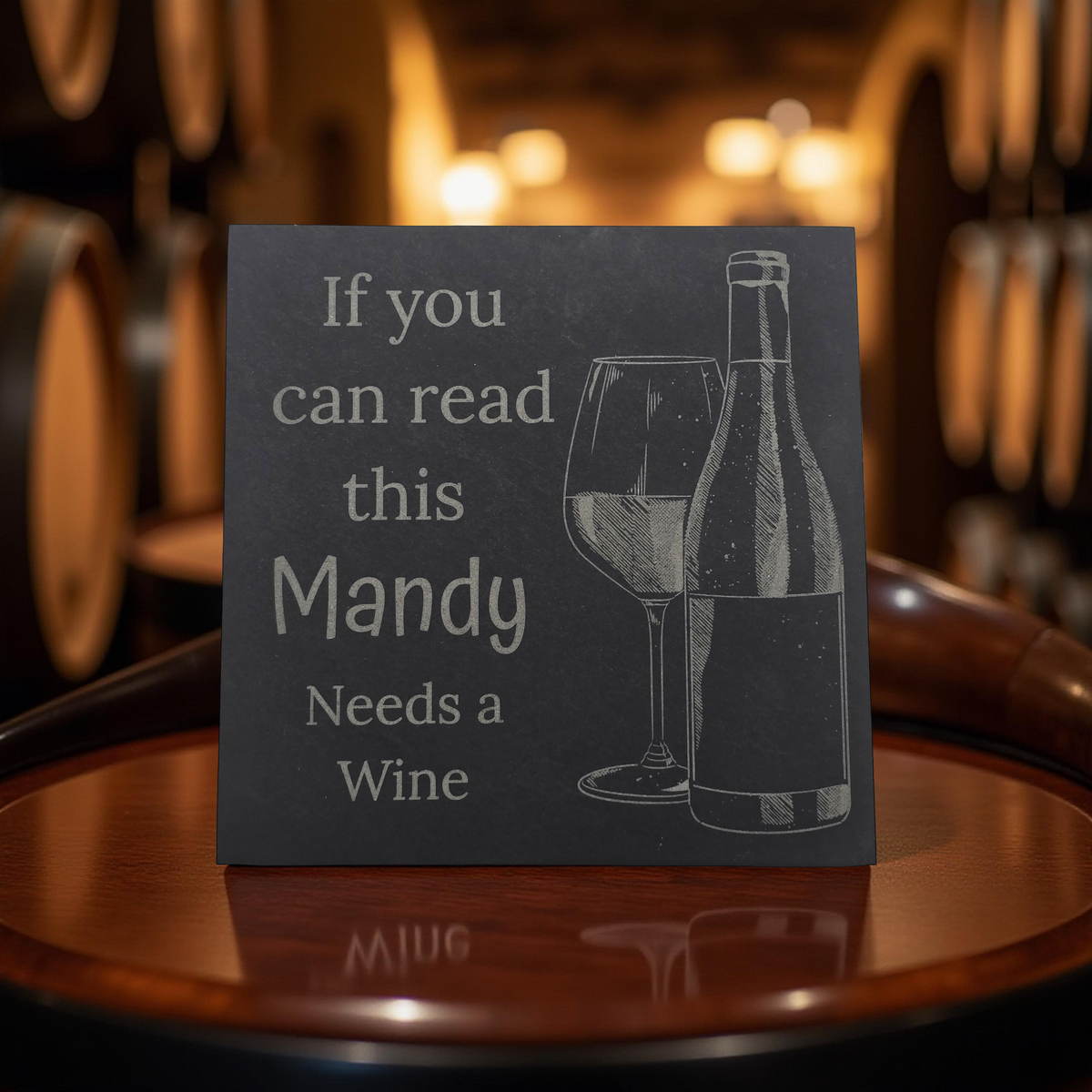 personalised coaster with wine bottle and glass illustration and text 'If you can read this Mandy Needs a Wine' on a wooden surface.