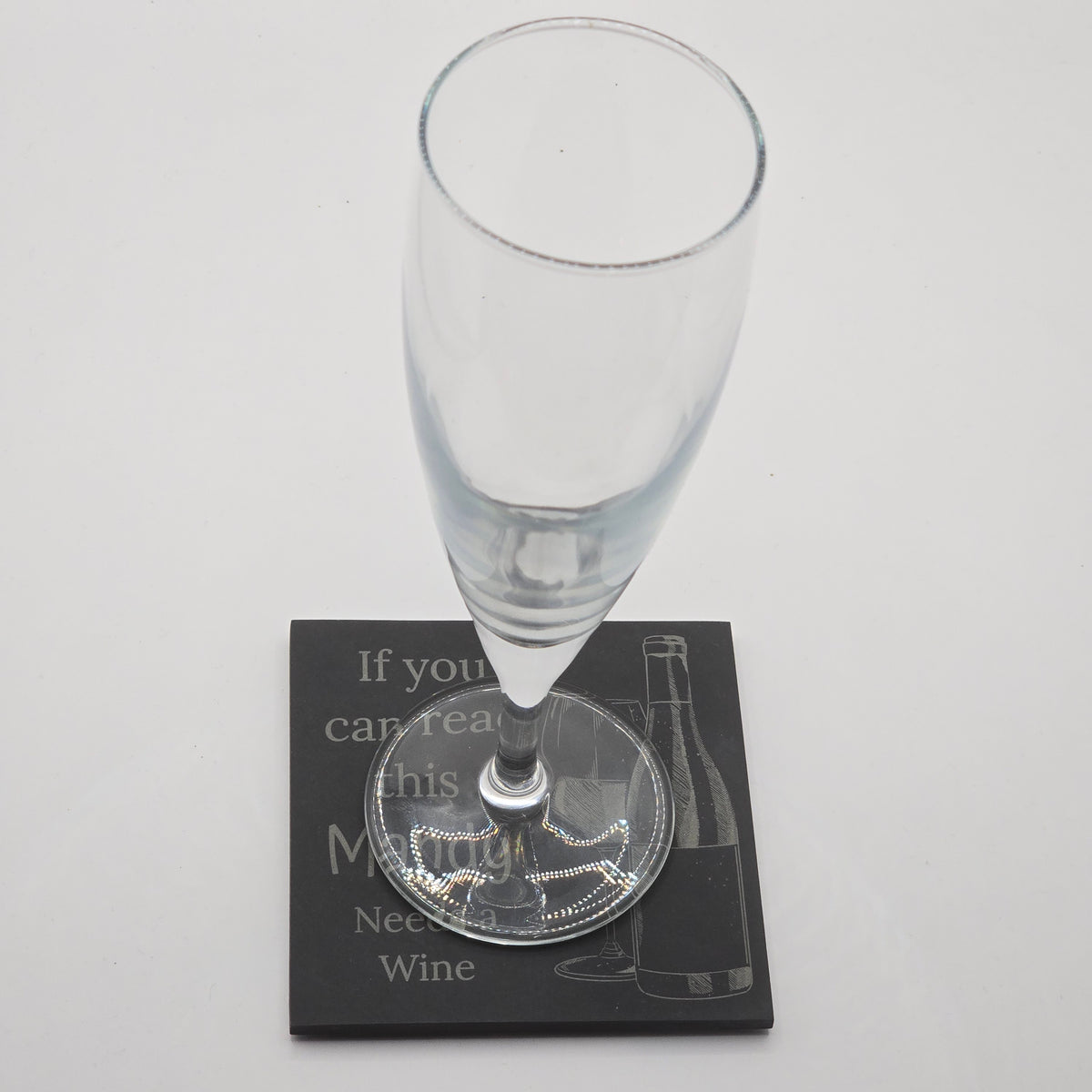 champaign flute resting on a custom coaster with the text "if you can read this Mandy needs a wine"