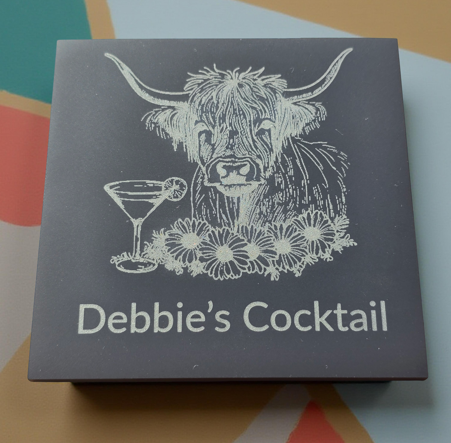 Box with a highland cow illustration and 'Debbie's Cocktail' text on a colorful background