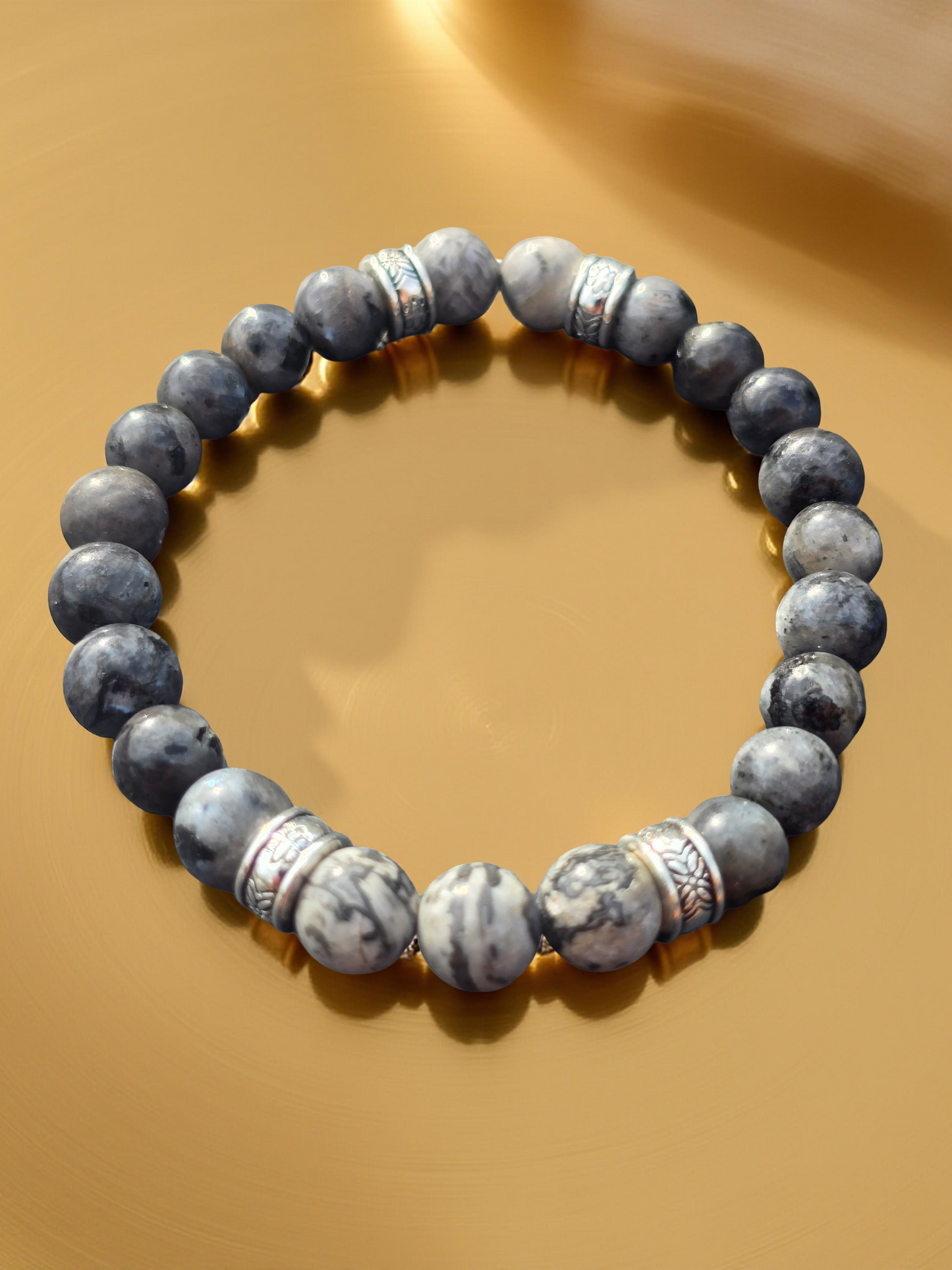 Gray beaded bracelet on a gold background