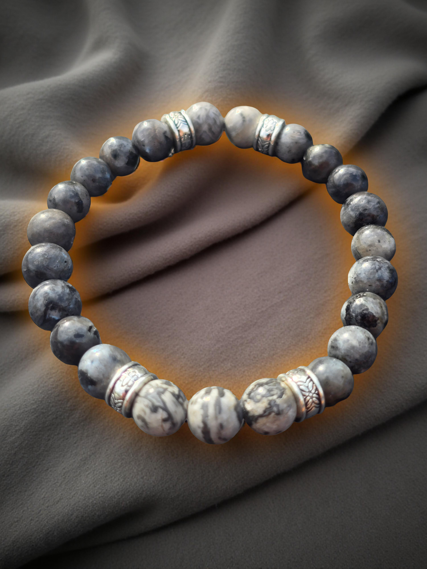 Gray beaded bracelet on a textured gray fabric background