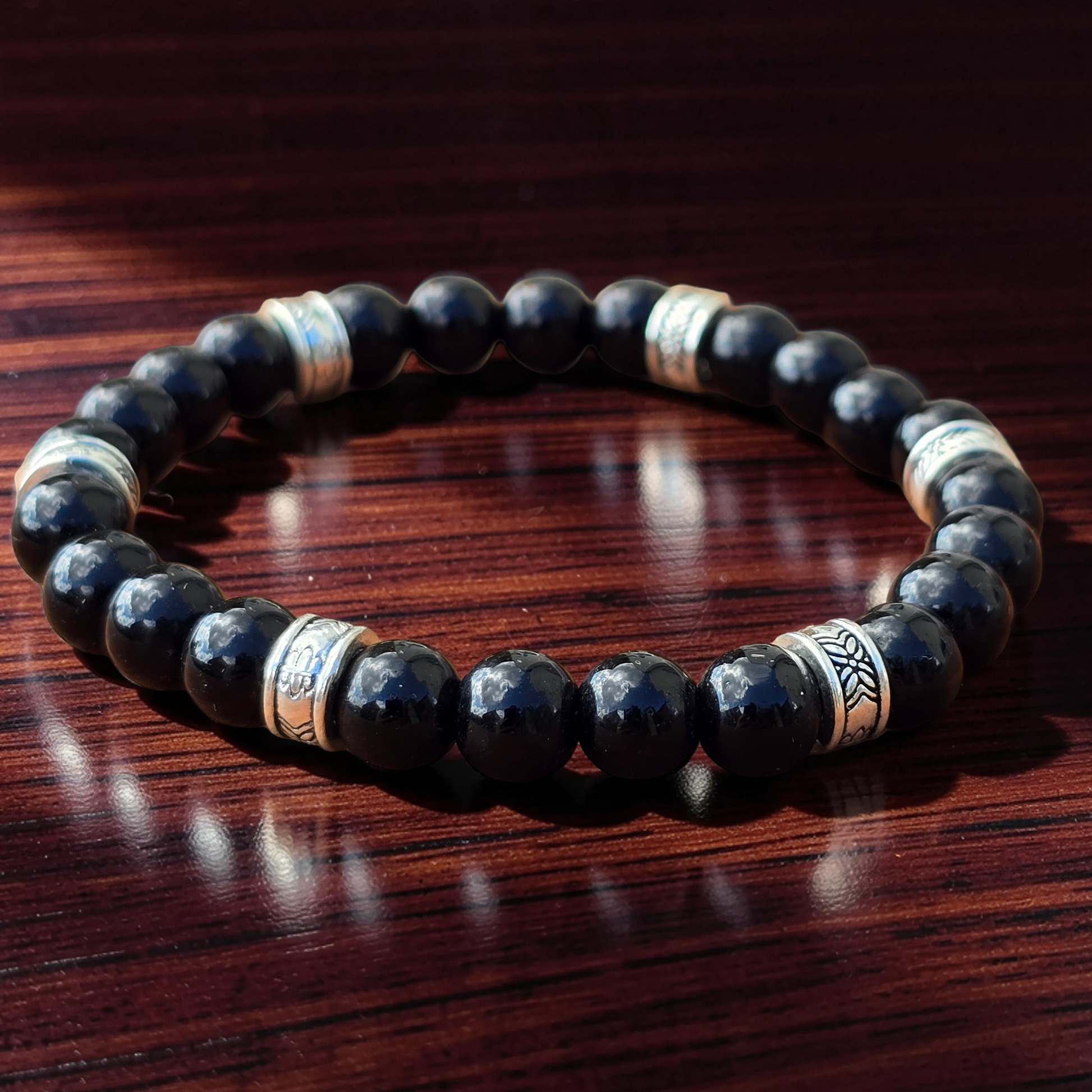 men's Black beaded bracelet with silver accents on a wooden surface