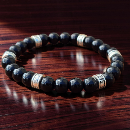 men's Black beaded bracelet with silver accents on a wooden surface