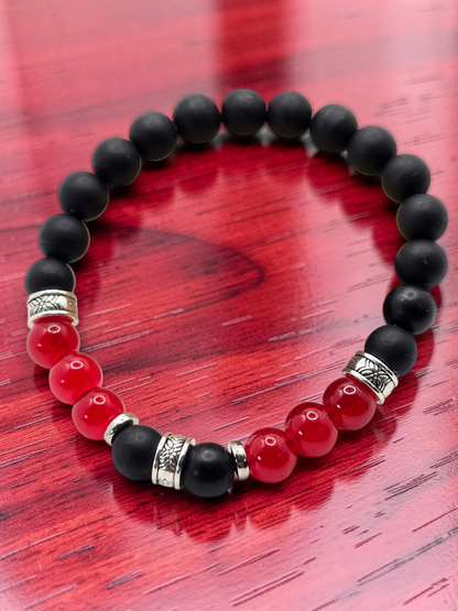 Mens Black and red beaded bracelet on a red wooden surface