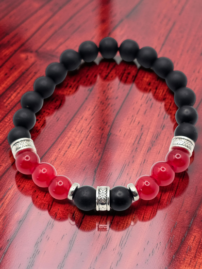 Black and red beaded bracelet on a wooden surface