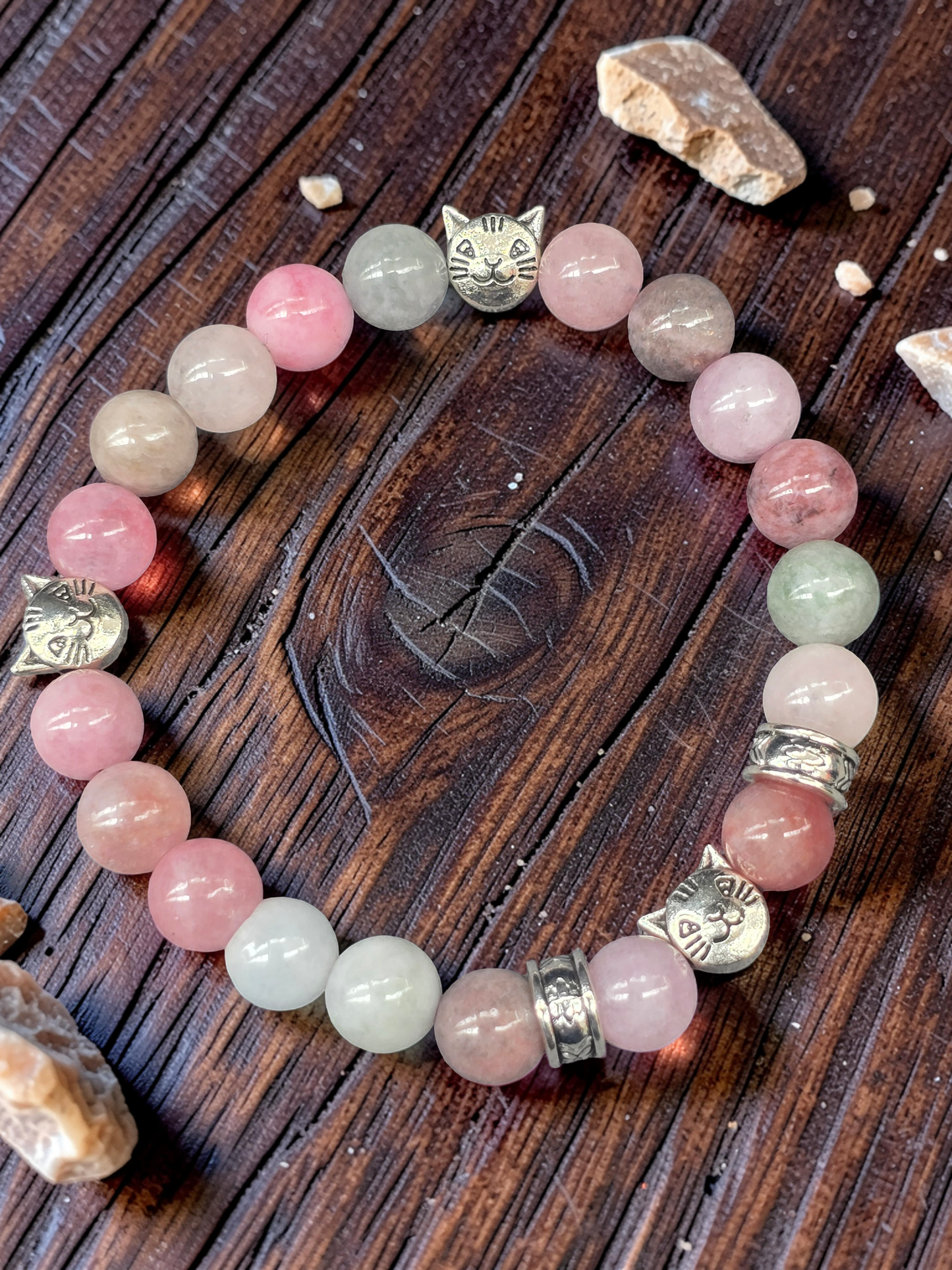 Cat themed Beaded bracelet with pink and green stone beads on a wooden surface