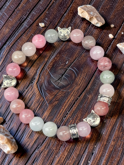 Cat themed Beaded bracelet with pink and green stone beads on a wooden surface