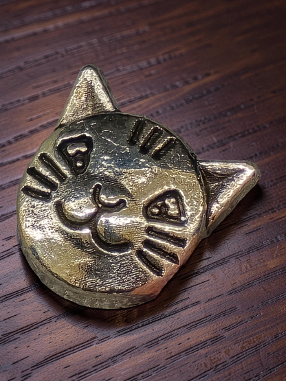 Silver cat-shaped bead on a wooden surface