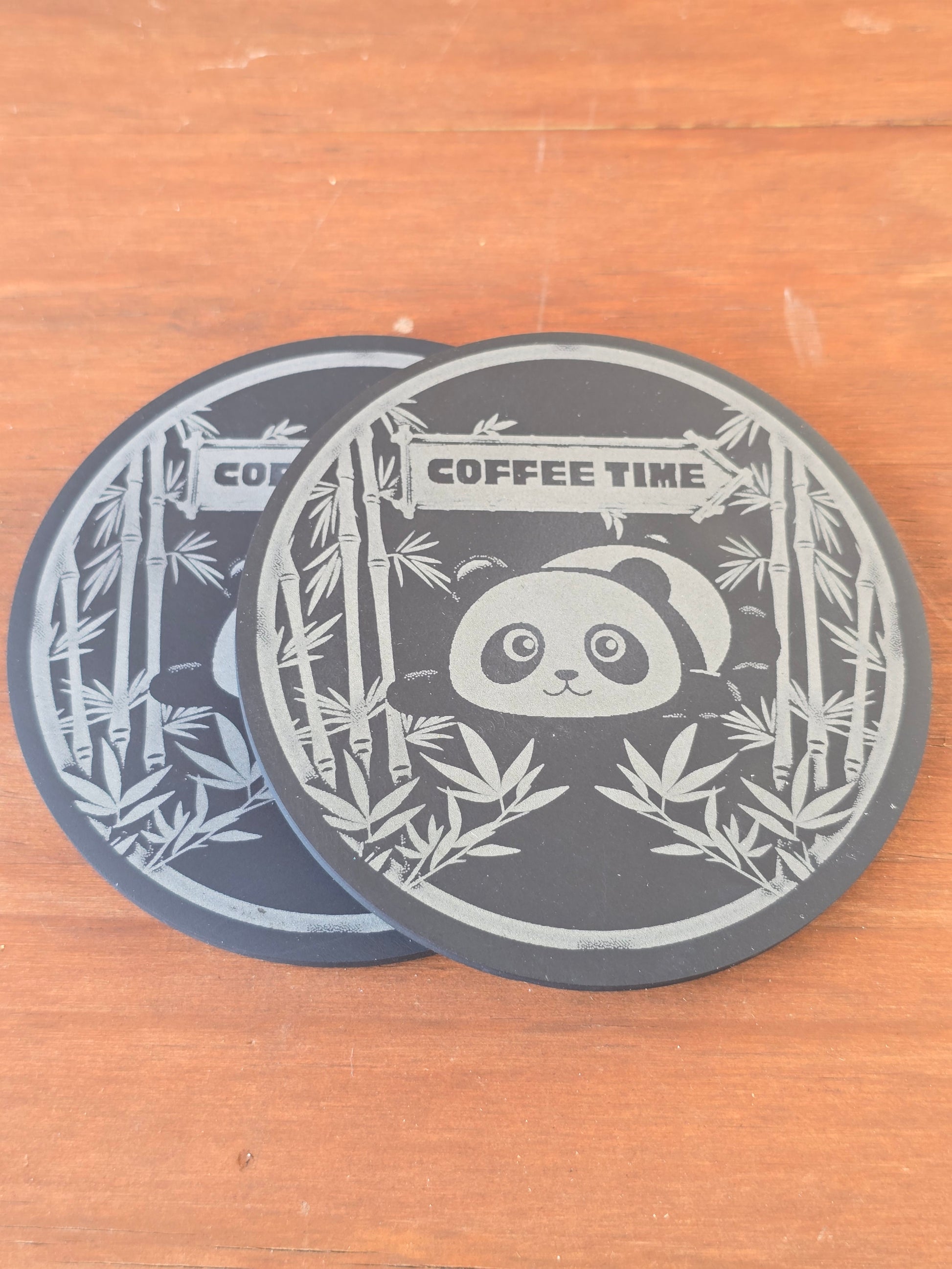 Decorative coaster with panda and bamboo design and 'Coffee Time' text on a wooden surface