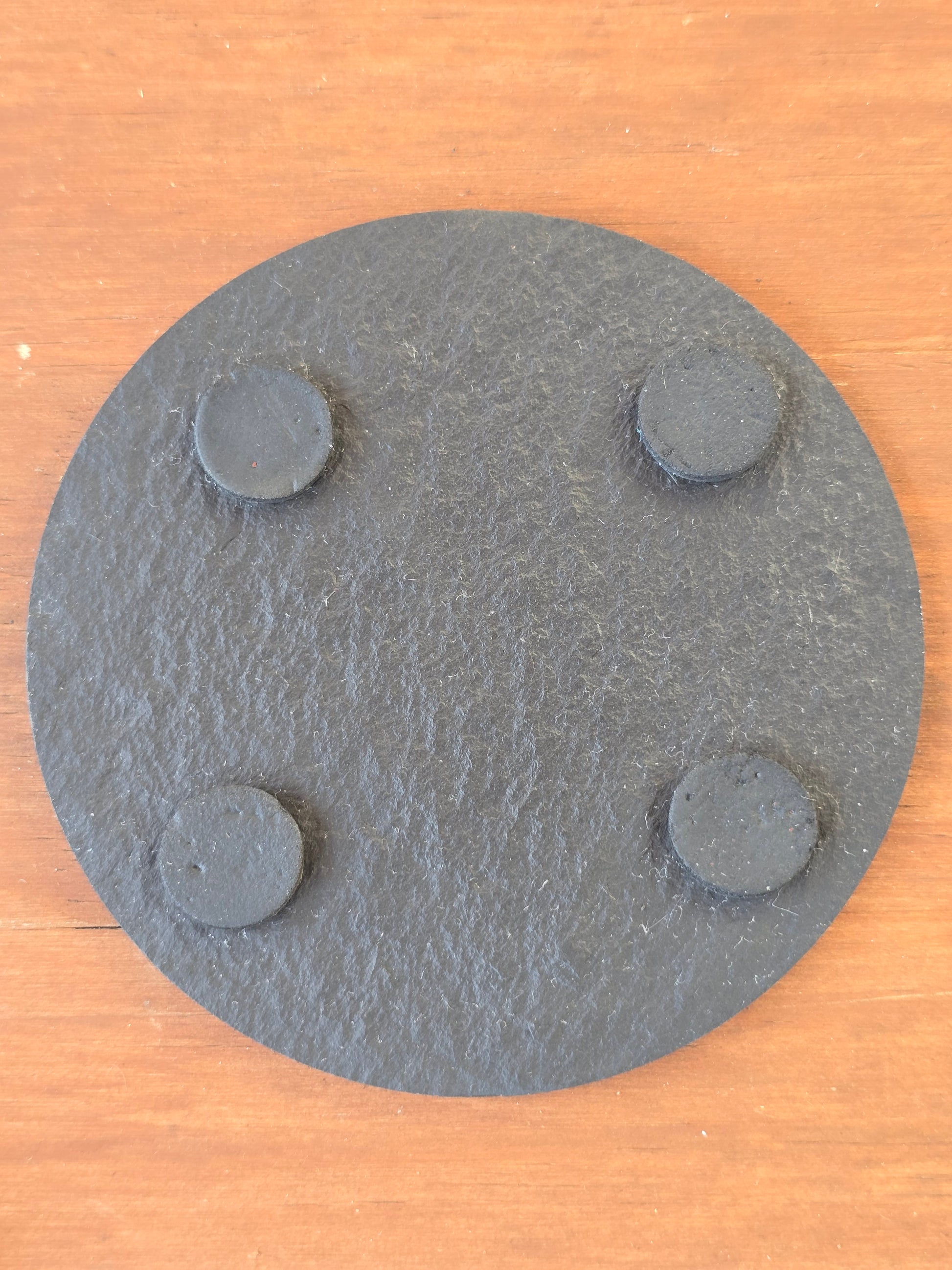 underside of a slate coaster with 4 felt feet