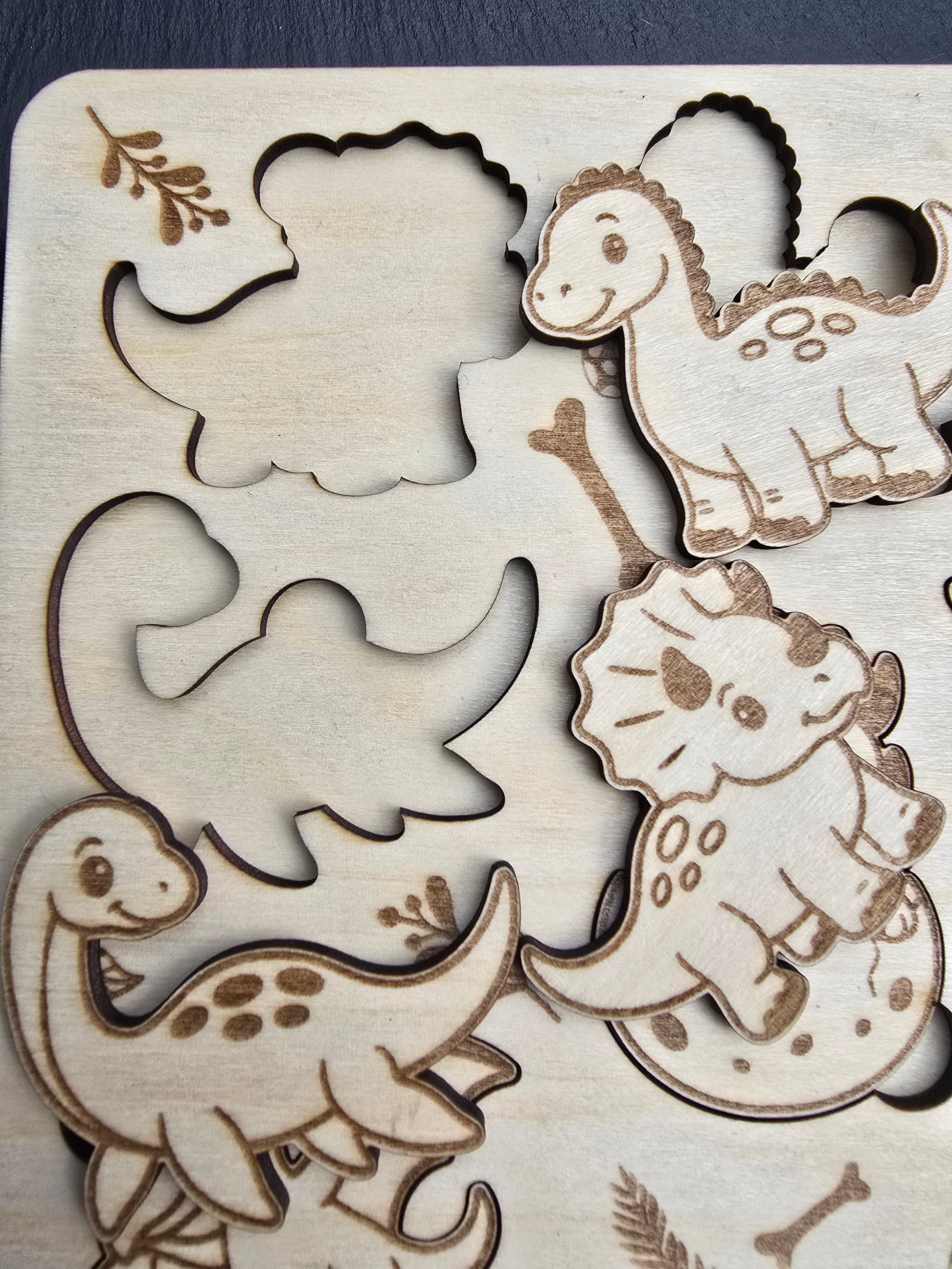 Wooden cut out shapes of Dinosaurs on a wooden board. puzzle for kids
