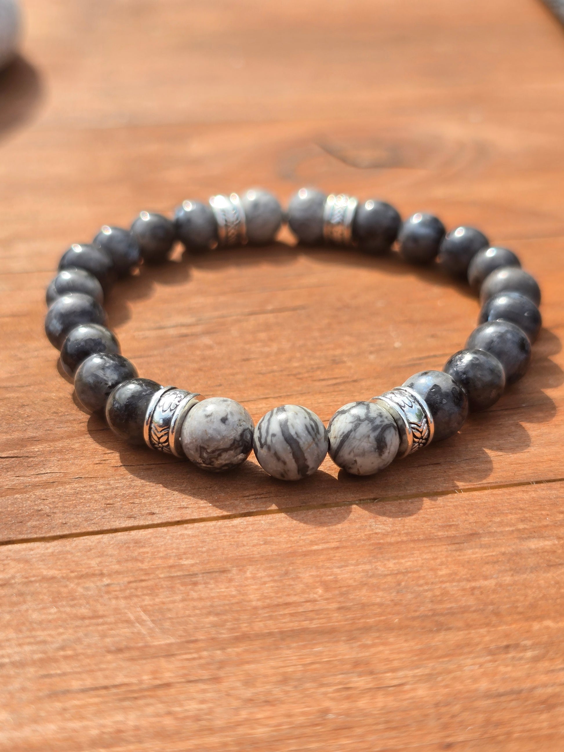 Men's Beaded bracelet with Grey and white stones on a wooden surface