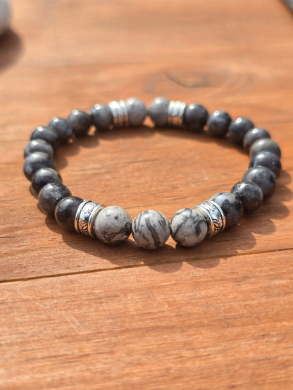 Men's Beaded bracelet with Grey and white stones on a wooden surface