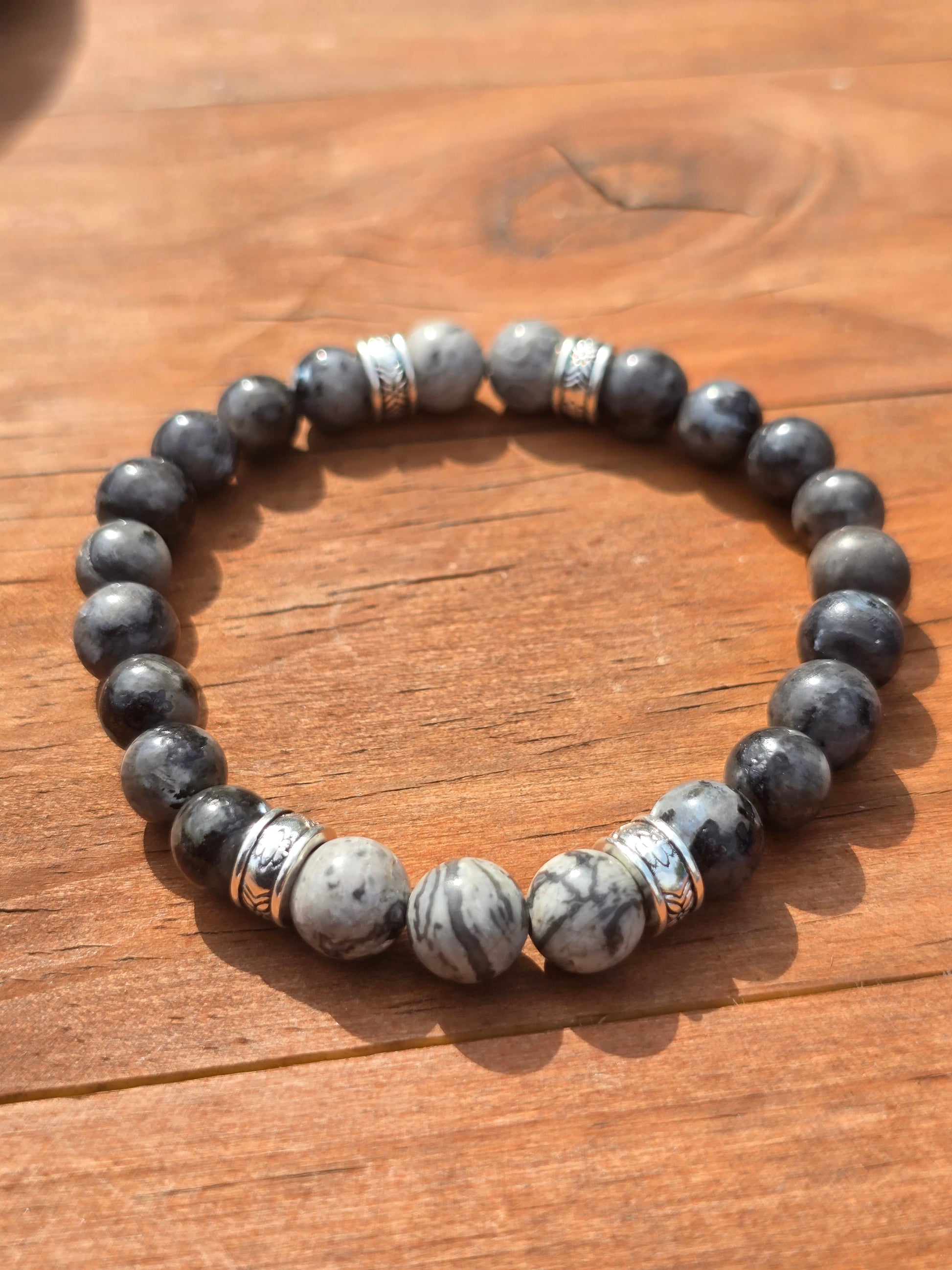 mens grey beaded elastic bracelet on a wooden surface