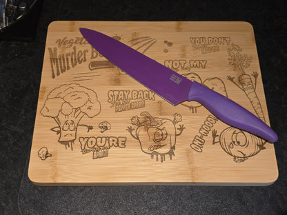 Purple knife on a wooden cutting board with cartoon vegetable designs