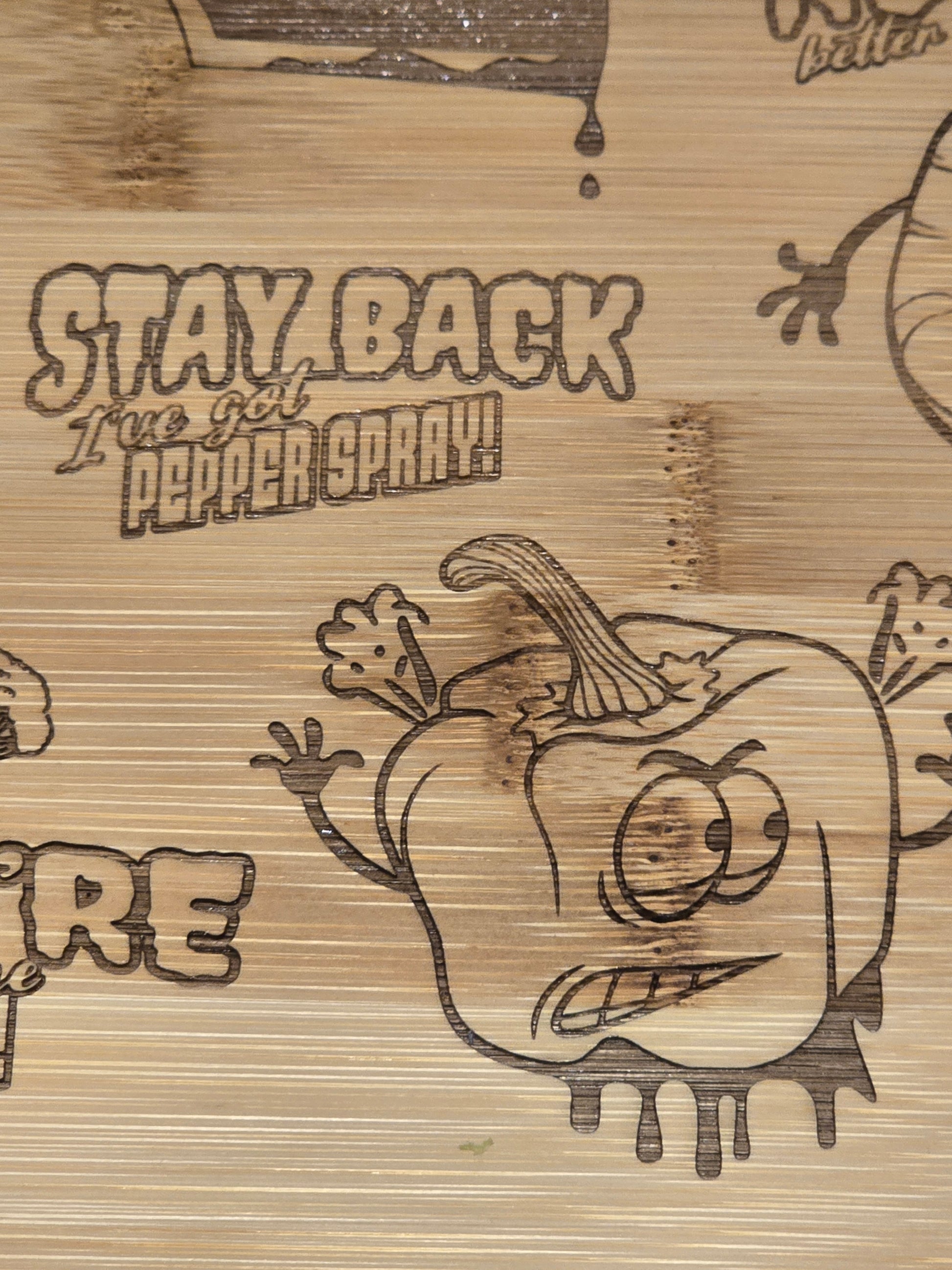 bamboo chopping board with etched pepper design and stay back I've got pepper spray text.
