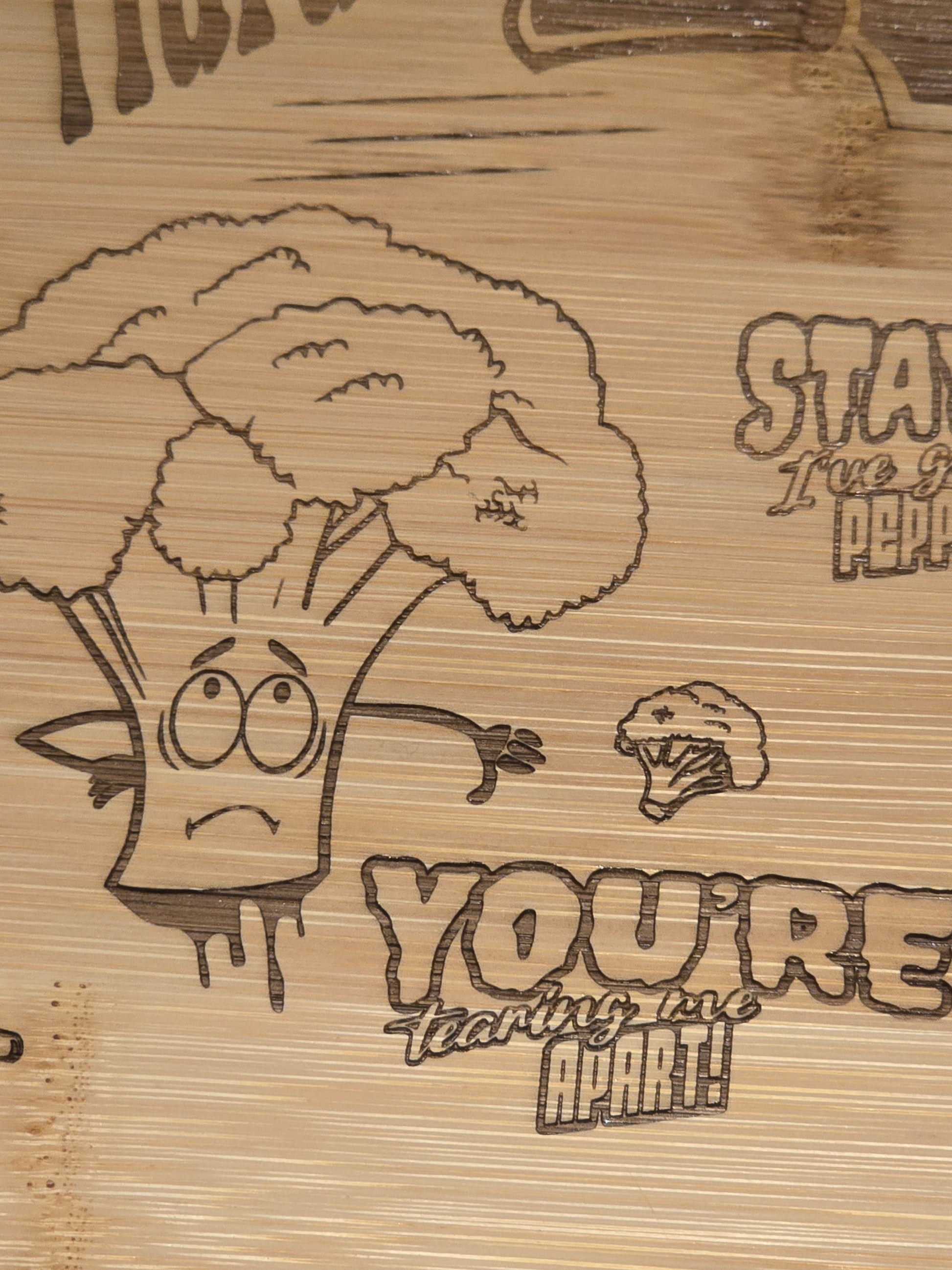 Wooden cutting board with engraved cartoon broccoli character and you're tearing me apart text