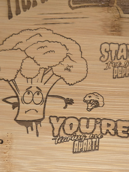 Wooden cutting board with engraved cartoon broccoli character and you're tearing me apart text